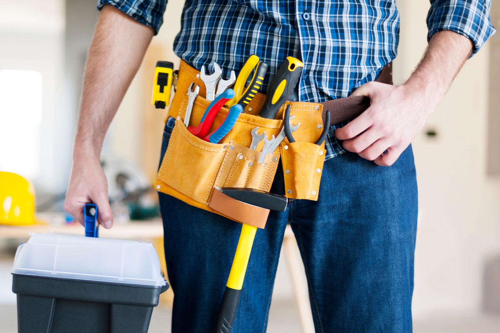 Mann mit Werkzeuggürtel und Werkzeugkoffer